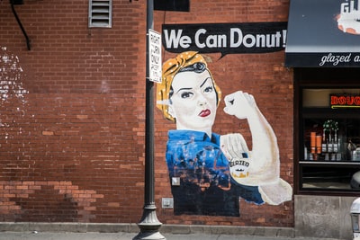 女权主义者meme画在墙上的标题,“我们可以甜甜圈!”
